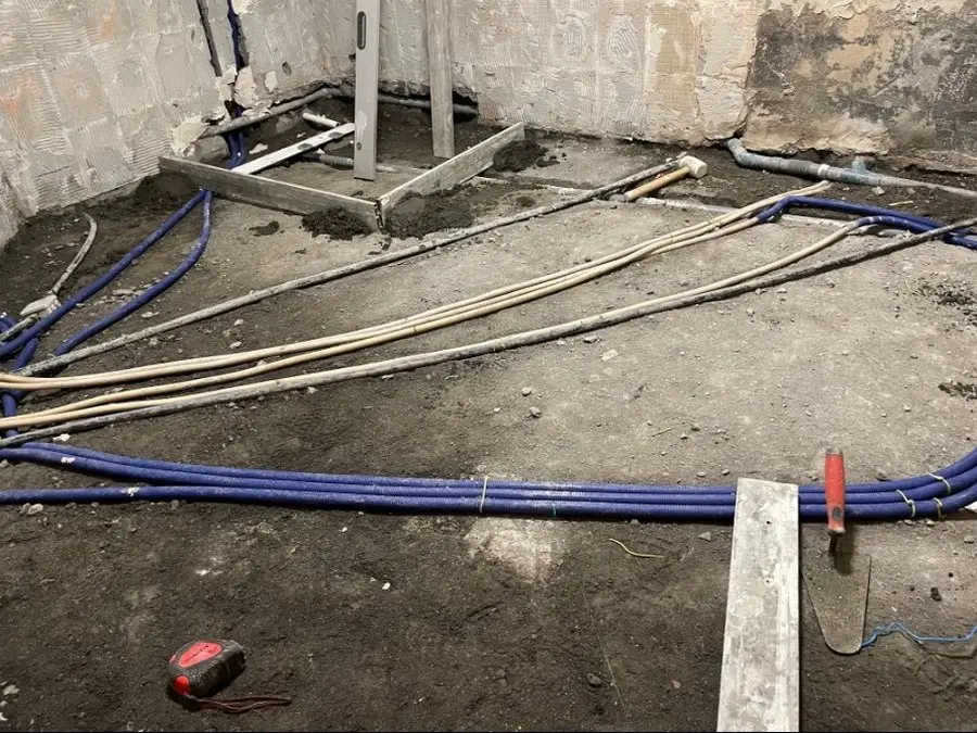 Réseaux d’eau et gaines électriques tirés sur la dalle avant coulage de la chape.