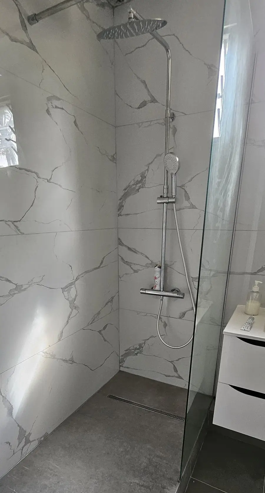 La même salle de bain livrée : douche à l'italienne, carrelage grand format