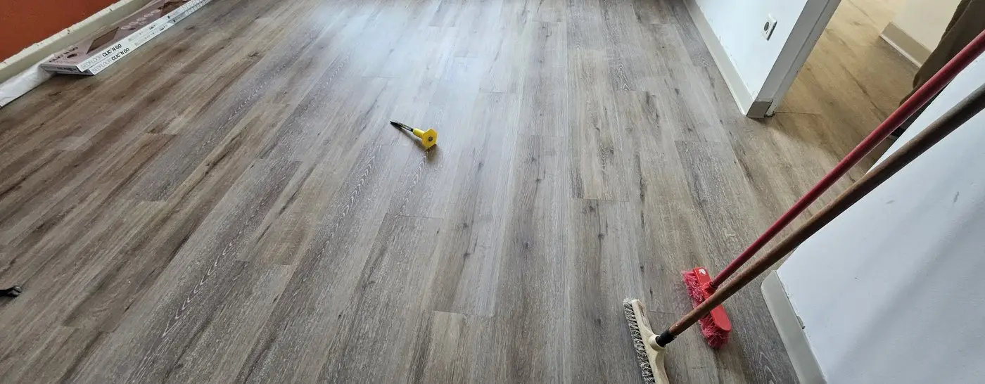 Le même espace après travaux : lames LVT posées, sol fini prêt à la mise en service.